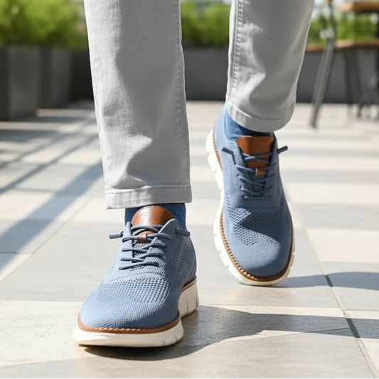 Person wearing blue sneakers with brown soles on a rooftop with plants and tables in the background.
